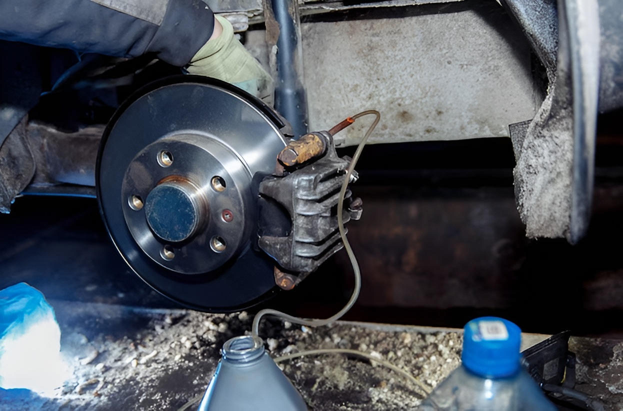 Mechanic performing brake bleeding on vehicle in Northern Beaches workshop.