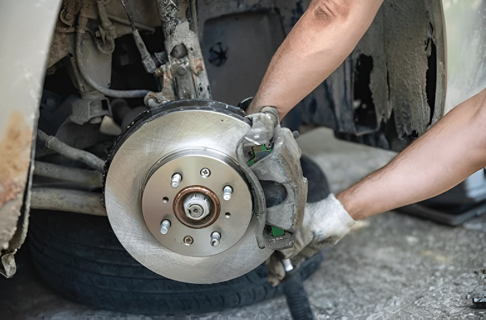 A mechanic is inspecting quality brake pads and rotors in a Brookvale workshop