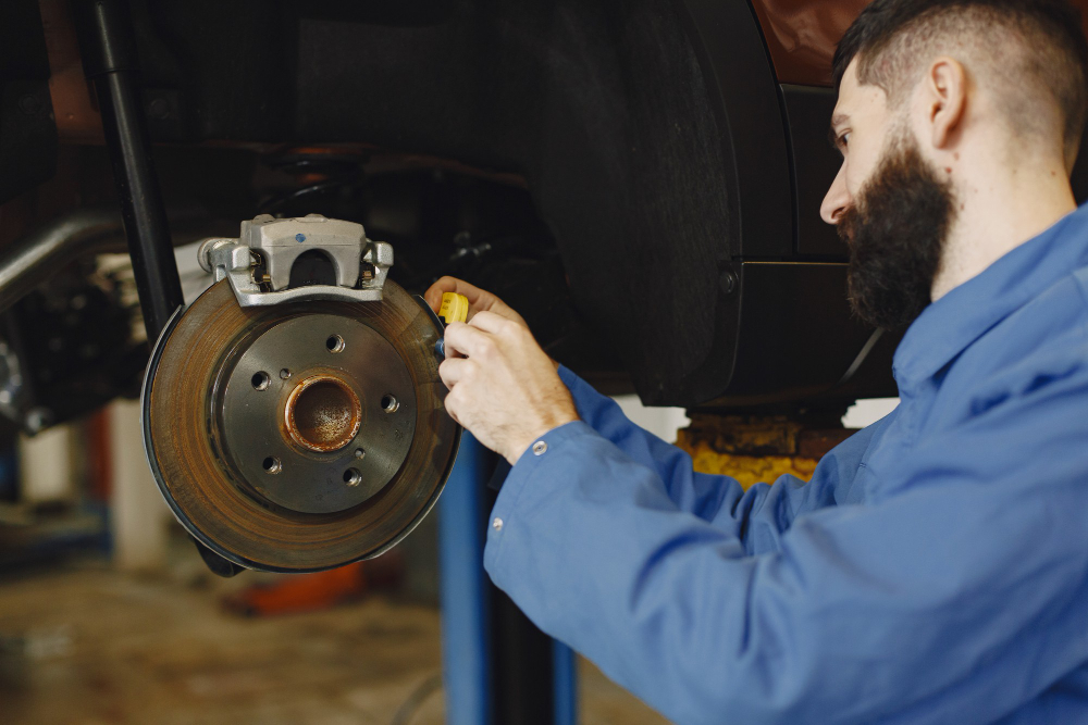 Mechanic inspecting brakes during professional car servicing